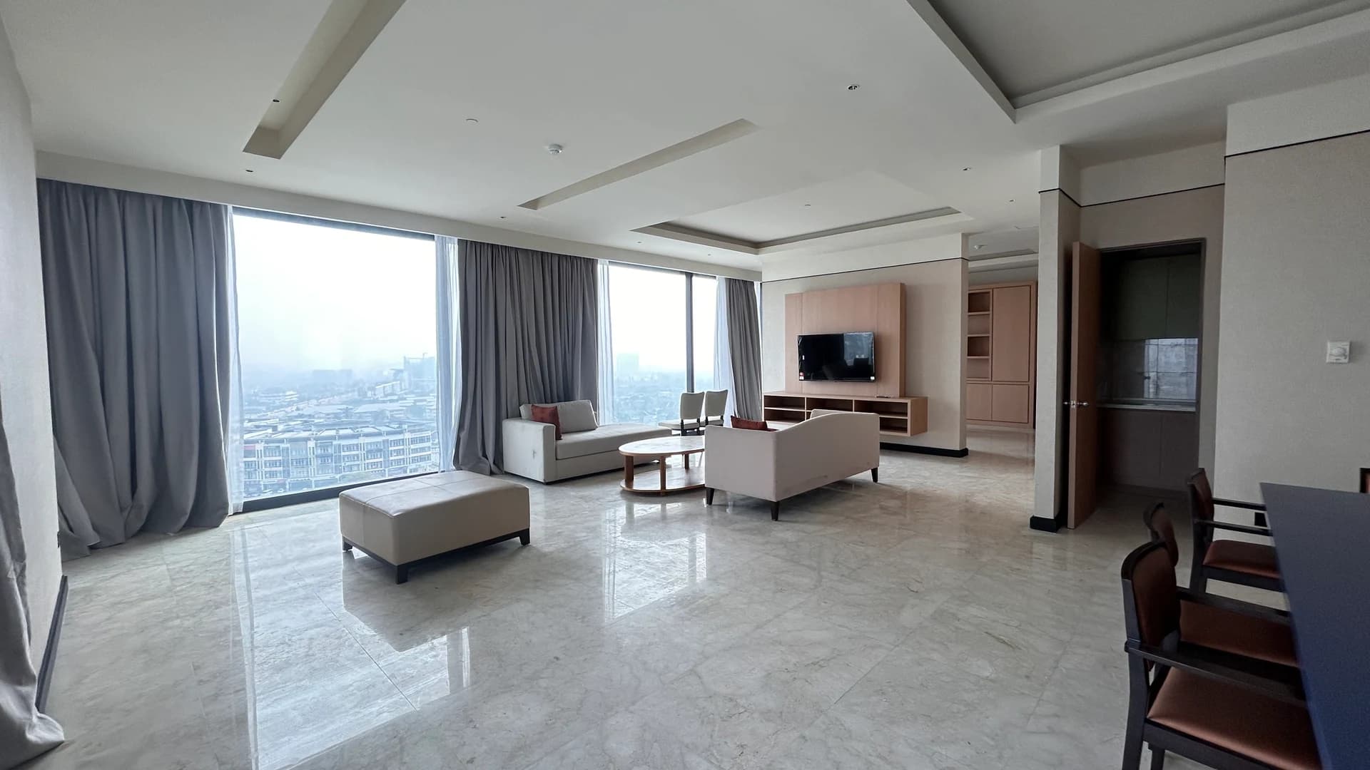 A suite with a lounge area and floor-to-ceiling windows