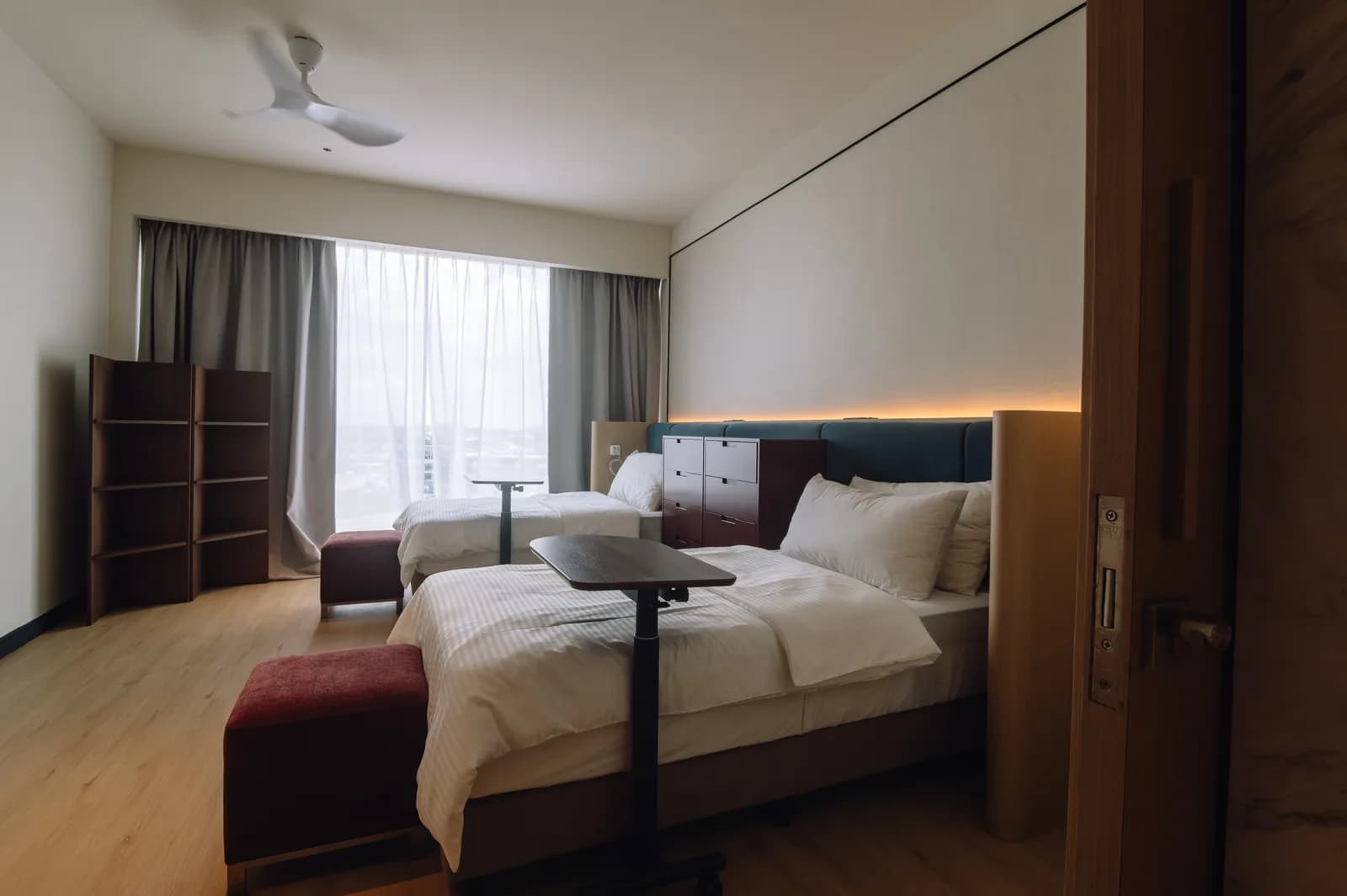 A twin bedroom with two beds and ottomans