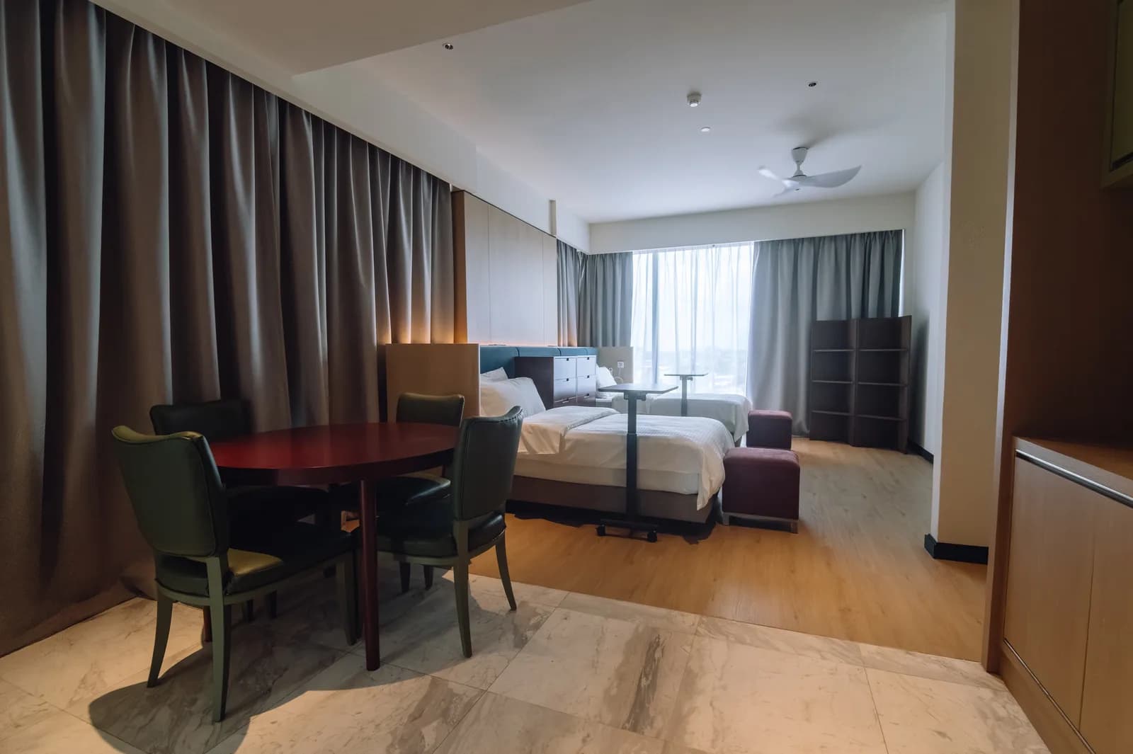 A twin suite with a dining table and city views