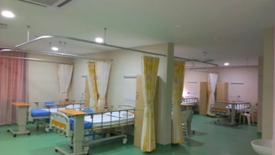 Eight-bed shared ward at Tabuan Healthcare and Nursing Centre with curtain dividers